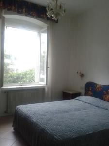 格拉多Villa Giulia的一间卧室设有一张床和一个大窗户