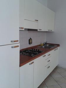 格拉多Villa Giulia的白色的厨房设有水槽和炉灶。