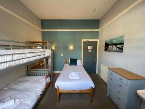 罗斯伯里罗斯伯里纽卡斯尔豪斯宾馆的一间卧室设有两张双层床和水槽