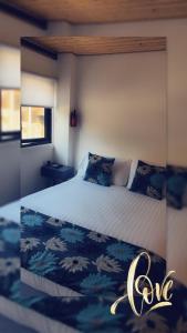 DrumahoeArdmore Log Cabins的一间卧室配有一张带蓝白色床单的大床