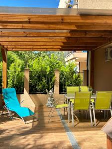 扎马迪ZEN Apartman Sunshine的露台配有椅子和桌子,甲板上配有桌子
