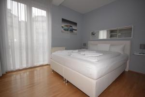 柏林柏林栖息地 - 带家具公寓 - 市中心的白色卧室内的白色床和白色窗帘