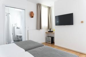巴黎棕榈阿斯托特尔酒店的白色卧室配有床和平面电视