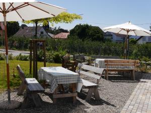 塞勒姆Pension & Café Schlupfwinkel的一个带桌椅和遮阳伞的庭院