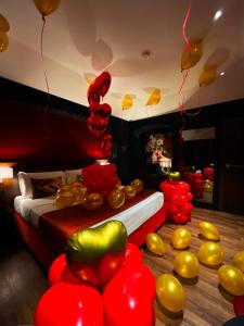 坎帕尼亚朱利亚诺Hotel Orizzonte的一间设有红色和金色气球的房间和一张床