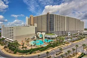 巴拿马城海滩Family-Friendly Panama City Beach Condo in Resort!的一座大型酒店,在一座建筑前设有一个游泳池