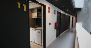马拉加Residencia de estudiantes Xior Málaga Teatinos solo estudiantes的走廊,带一间厨房的房间和走廊