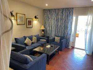 阿莱曼Patio suit, Porto marina的客厅配有蓝色的沙发和桌子