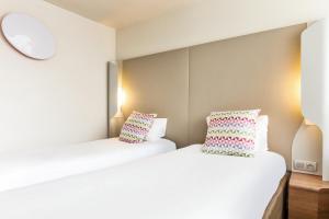 孔夫朗-圣奥诺里讷钟楼康弗兰圣奥诺丽娜酒店的配有两张床铺的客房配有两张枕头