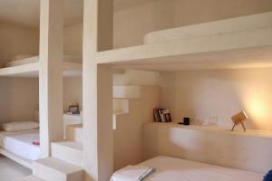 Sant Francesc de s'EstanyLa Pandilla Ibiza的带两张双层床和楼梯的客房