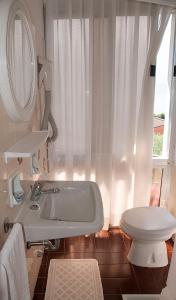 利莫内-苏尔加达花园酒店的白色的浴室设有浴缸和卫生间。