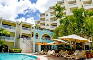 基督教堂市Barbados Beach Club Resort - All Inclusive的一个带游泳池、椅子和遮阳伞的度假村