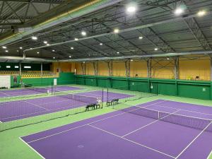 AizkraukleVILARHOTEL的一个带两个网球场的室内网球场