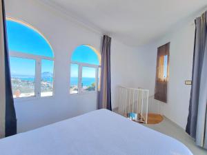 阿桂拉斯Catalejo chalet casa rural 18 plazas的卧室配有白色的床和2扇窗户。