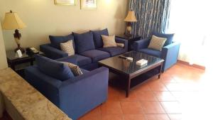 阿莱曼Patio suit, Porto marina的客厅配有蓝色的沙发和咖啡桌