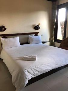 色军Siwasom Resort Sakon Nakhon的一张白色的大床,上面有白色毛巾
