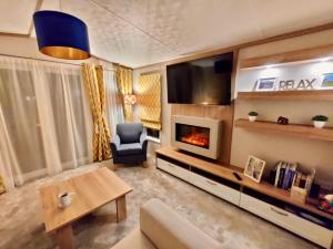 卡莱尔Discover, Relax, Enjoy - All-Round Luxury Lodge的带沙发和壁炉的客厅