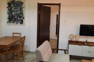 罗安达28A, Lumir Apartamento #8, Luanda的客厅配有椅子、桌子和电视