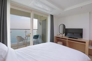 束草市Heavenmark in Sokcho的酒店客房设有一张床,享有海景。