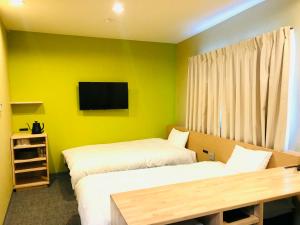 高知高砂酒店 的客房设有两张床和一台墙上的电视。