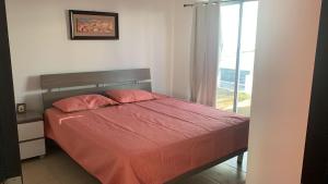 里奥阿托Villa en Ibiza Residence II, disfruta en familia的一间卧室配有一张带红色床单的床和一扇窗户。