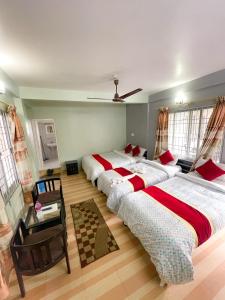 博卡拉丰收圆月乡村民宿的一间带三张床和吊扇的卧室