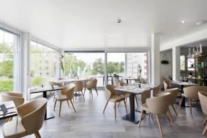 Orbe马赛克酒店的餐厅设有桌椅和大窗户。