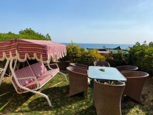 艾因苏赫纳New Panorama Sea View Villa Family的桌椅、雨伞和桌椅