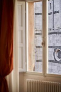 锡耶纳马尼菲科宫殿住宿加早餐旅馆的享有砖墙景致的窗户