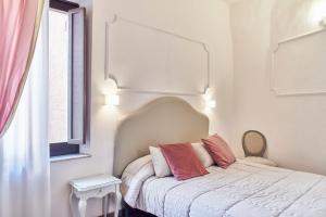 锡耶纳马尼菲科宫殿住宿加早餐旅馆的一间卧室配有一张带两个粉红色枕头的床