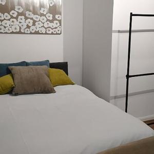 LitherlandLitherland Apartment的一间卧室配有白色床和黄色枕头
