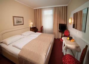 萨尔茨堡加雷兹提恩萨尔兹堡酒店的酒店客房设有一张大床和一张桌子。