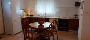 耶拉基尼COUNTRY HOUSE IN OLIVE GROVE - Gerakini的厨房配有桌椅和冰箱。