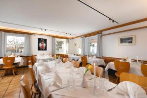 埃夫林根基兴Zur Blume Hotel & Restaurant Efringen-Kirchen bei Basel的餐厅设有白色的桌椅和窗户。