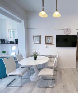 TopuskoTop Art Topusko Apartments的白色的用餐室配有白色的桌椅