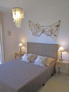 兰卡Apartament a les cales de Llançà en residència privada amb piscina的一间卧室配有一张带两张桌子和两盏灯的床。