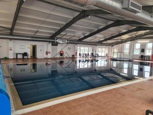 库伯特Mawgan Pads Perranporth的一座空游泳池,位于一座拥有地板和天花板的建筑中