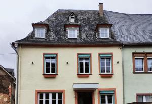 赖尔Gästehaus Weingut Schier im historischen Zehnthof的白色的房子,设有窗户和黑色屋顶