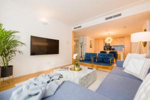 维也纳Rafael Kaiser - Premium Apartments City Centre - Contactless 24h Check-In的客厅配有蓝色的沙发和电视
