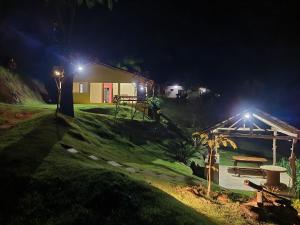 多明戈斯马丁斯Espaço inteiro: Casa de campo nas montanhas的夜晚带长凳和野餐桌的房子