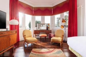 法尔茅斯切尔西旅馆的一间卧室配有红色窗帘、一张床和一张书桌