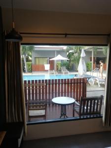 普吉镇ViVi Hotel Resort的一个带桌椅的阳台和一个游泳池