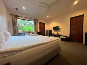 普吉镇ViVi Hotel Resort的一间卧室设有一张大床和一个窗户。
