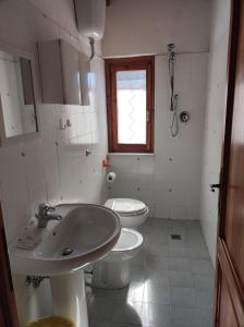 库蒂利亚诺Agriturismo il fosso的一间带水槽和卫生间的浴室以及窗户。