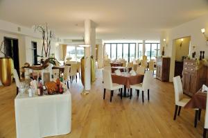 洛斯海姆豪彻沃德沃费勒酒店的一间配备有白色椅子和桌子的用餐室