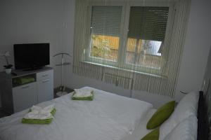 毛科Frézia Apartman的一间卧室配有一张床,上面有两条毛巾