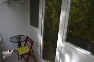 毛科Frézia Apartman的门廊上的椅子和桌子,窗户