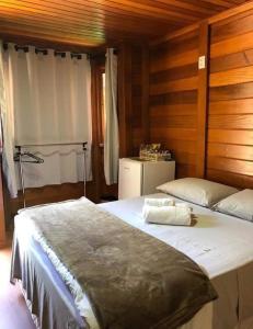 多明戈斯马丁斯Pousada Recanto Viva a Vida的一间卧室配有两张床和一台冰箱