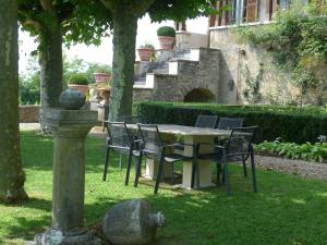 CeyzériatClos de Mont July, chambres avec vue et terrasse dans demeure historique的花园内桌椅,花园内有一座建筑