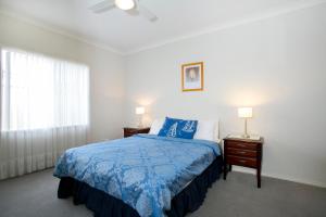 埃利奥特港埃利奥特港度假屋全季酒店的一间卧室配有一张蓝色的床,配有两个床头柜和两盏灯